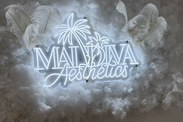 The illuminated Maldiva Aesthetics sign inside the Newport clinic
