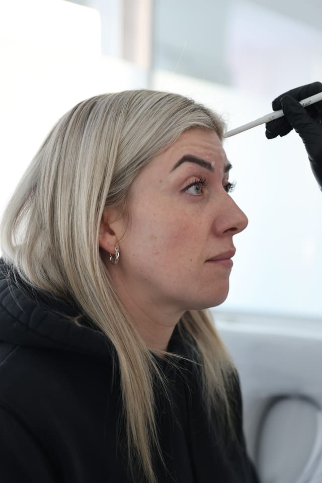 A client having the brow mapped out before a brow lift treatment