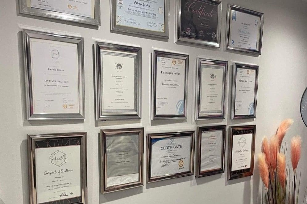 Framed training certificates and accreditations on the wall of the Maldiva Aesthetics clinic